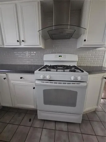 a stove top oven sitting inside of a kitchen