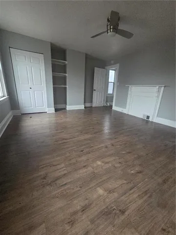 an empty room with windows and cabinet