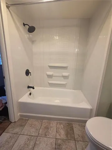 a bathroom with a bathtub and a toilet