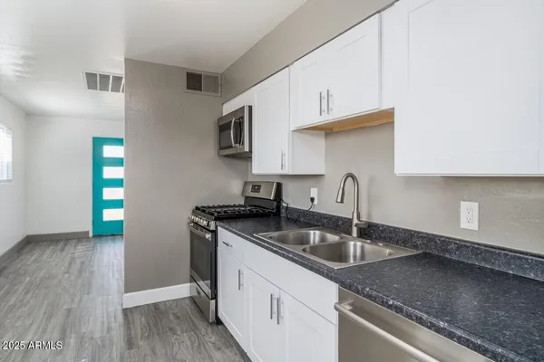 a kitchen with granite countertop a sink and a stove top oven