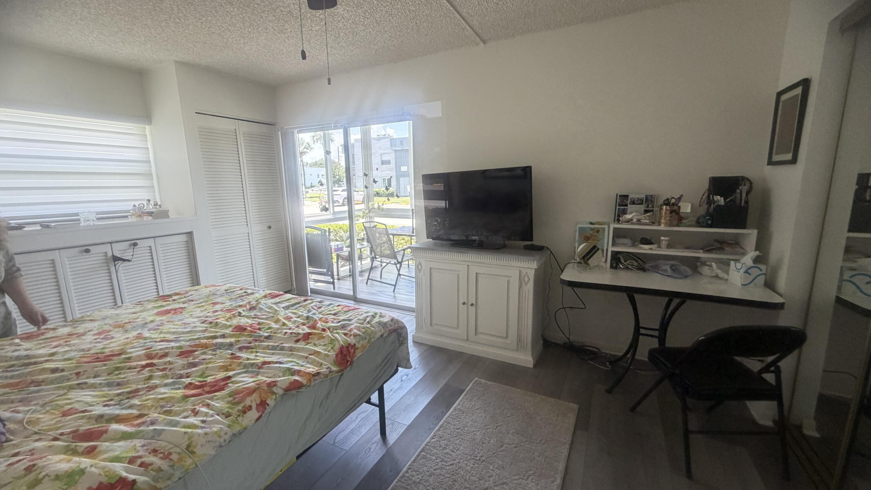 930 Normandy Trail Delray Beach, FL 33484 - Photo 11 of 34 a bedroom with a bed and a flat screen tv