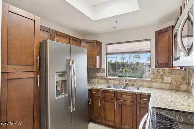 a kitchen with stainless steel appliances granite countertop a refrigerator and a sink
