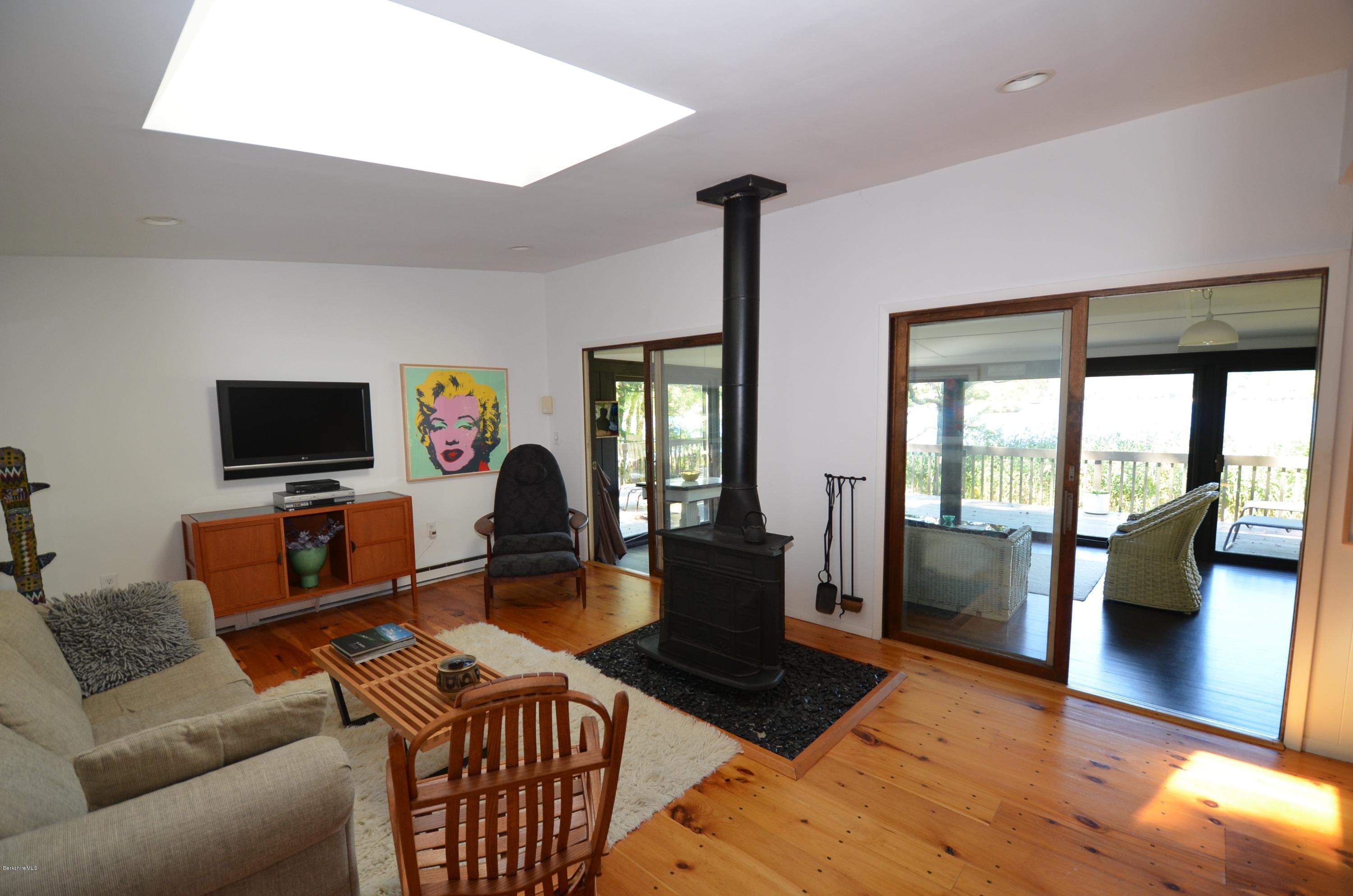 16 Point Road Monterey, MA 01245 - Photo 12 of 18 a living room with furniture a flat screen tv and a floor to ceiling window