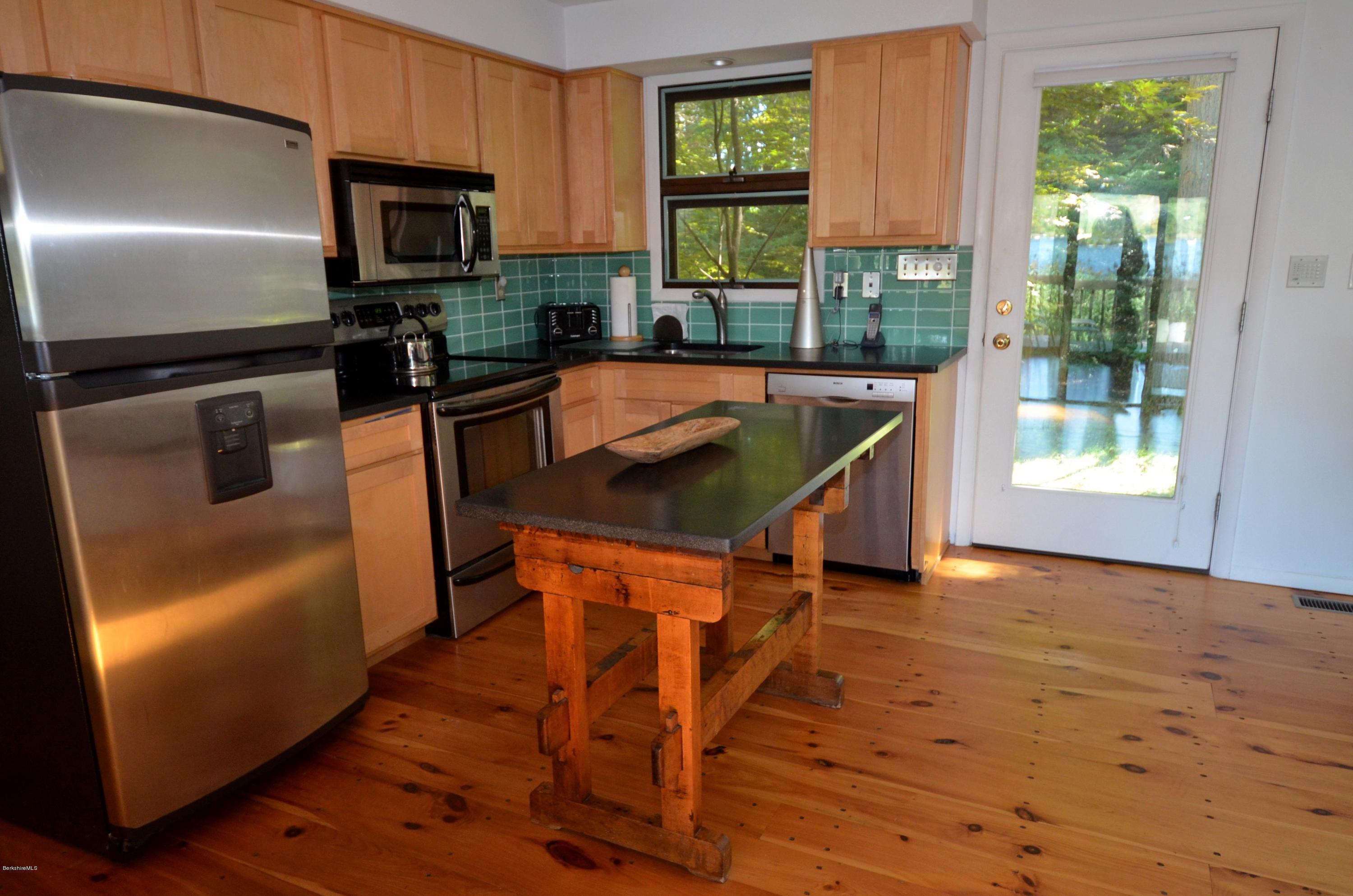 16 Point Road Monterey, MA 01245 - Photo 14 of 18 a kitchen with stainless steel appliances granite countertop a refrigerator a stove top oven a sink dishwasher and wooden cabinets with wooden floor