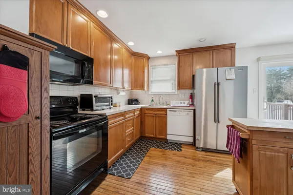 a kitchen with a sink a microwave a refrigerator and cabinets