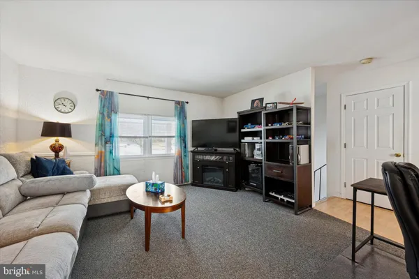 a living room with furniture a rug and a window