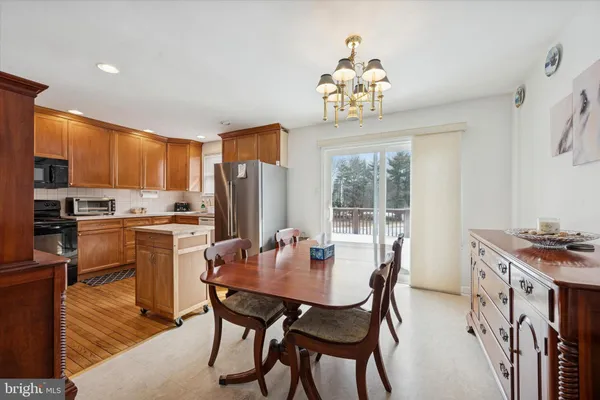 a dining room with a table chairs and kitchen view