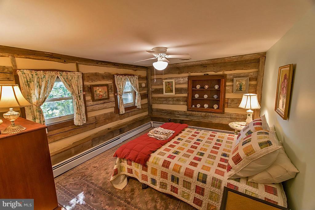 1209 Libby's Ridge Road Berkeley Springs, WV 25411 - Photo 24 of 30 a bedroom with a bed and wooden floor