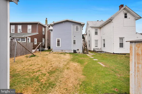 a view of a house with backyard and wooden fence