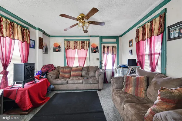 a living room with furniture ceiling fan and a window