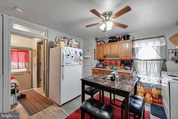 a kitchen with stainless steel appliances granite countertop a refrigerator a microwave a stove and a dining table with wooden floor