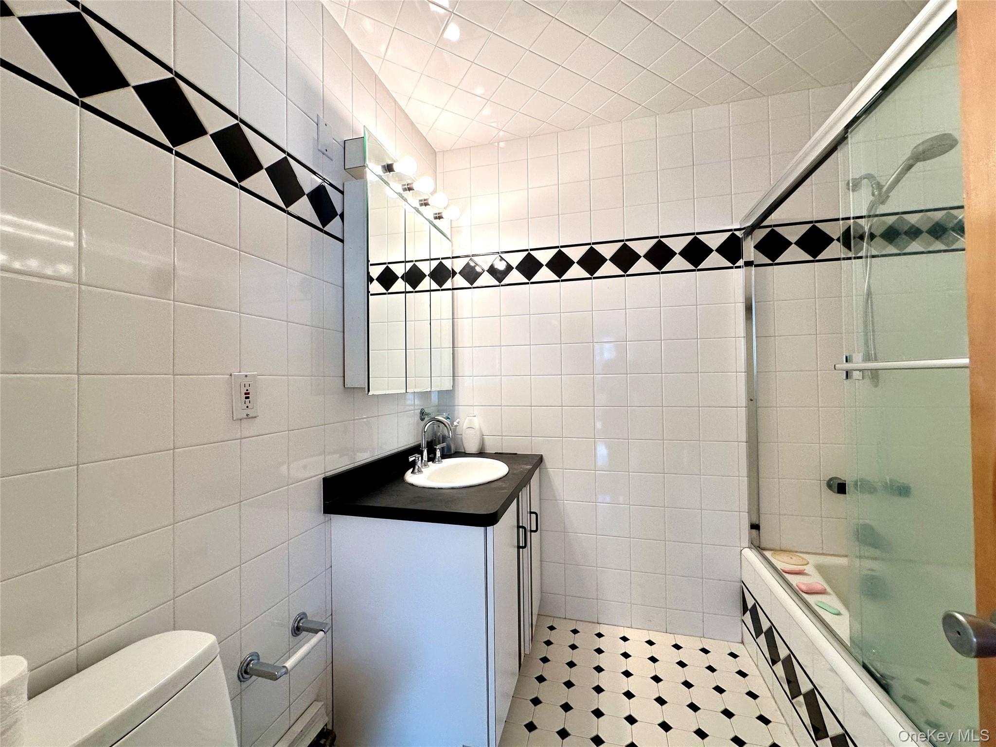 1027 Windermere Road Franklin Square, NY 11010 - Photo 13 of 43 a bathroom with a sink a toilet and shower