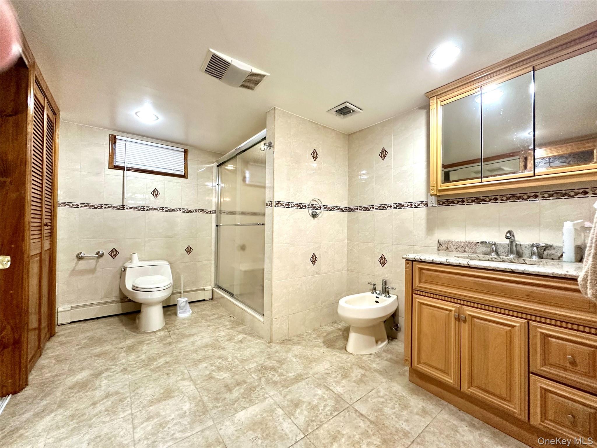 1027 Windermere Road Franklin Square, NY 11010 - Photo 34 of 43 a bathroom with a toilet sink double vanity and mirror
