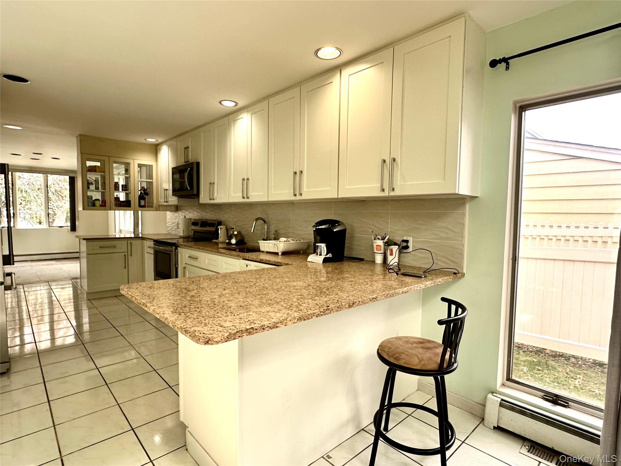 1027 Windermere Road Franklin Square, NY 11010 - Photo 5 of 43 a kitchen with stainless steel appliances granite countertop a sink refrigerator and cabinets