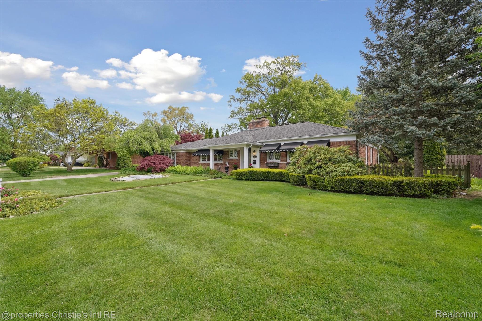 511 South Gulley Road Dearborn, MI 48124 - Photo 4 of 43 Brick exterior home with a gabled roof, established landscaping, and a manicured lawn