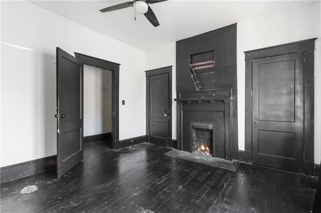 1329 Allene Avenue Southwest Atlanta, GA 30310 - Photo 12 of 20 an empty room with wooden floor fireplace and windows