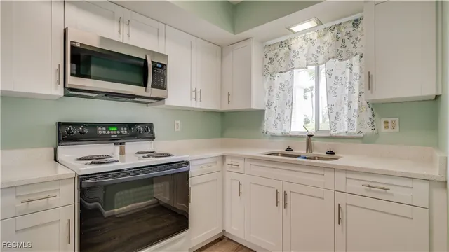 a kitchen with a sink stove and microwave