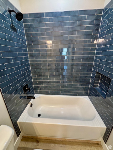 1184 West 3250 North Ogden, UT 84414 - Photo 44 of 69 Bathroom featuring a white tub, dark blue subway tile shower surround, matte black shower fixtures, and a recessed shower niche