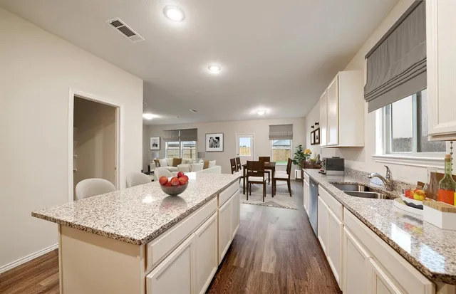 a kitchen with stainless steel appliances granite countertop a lot of counter space and wooden floors