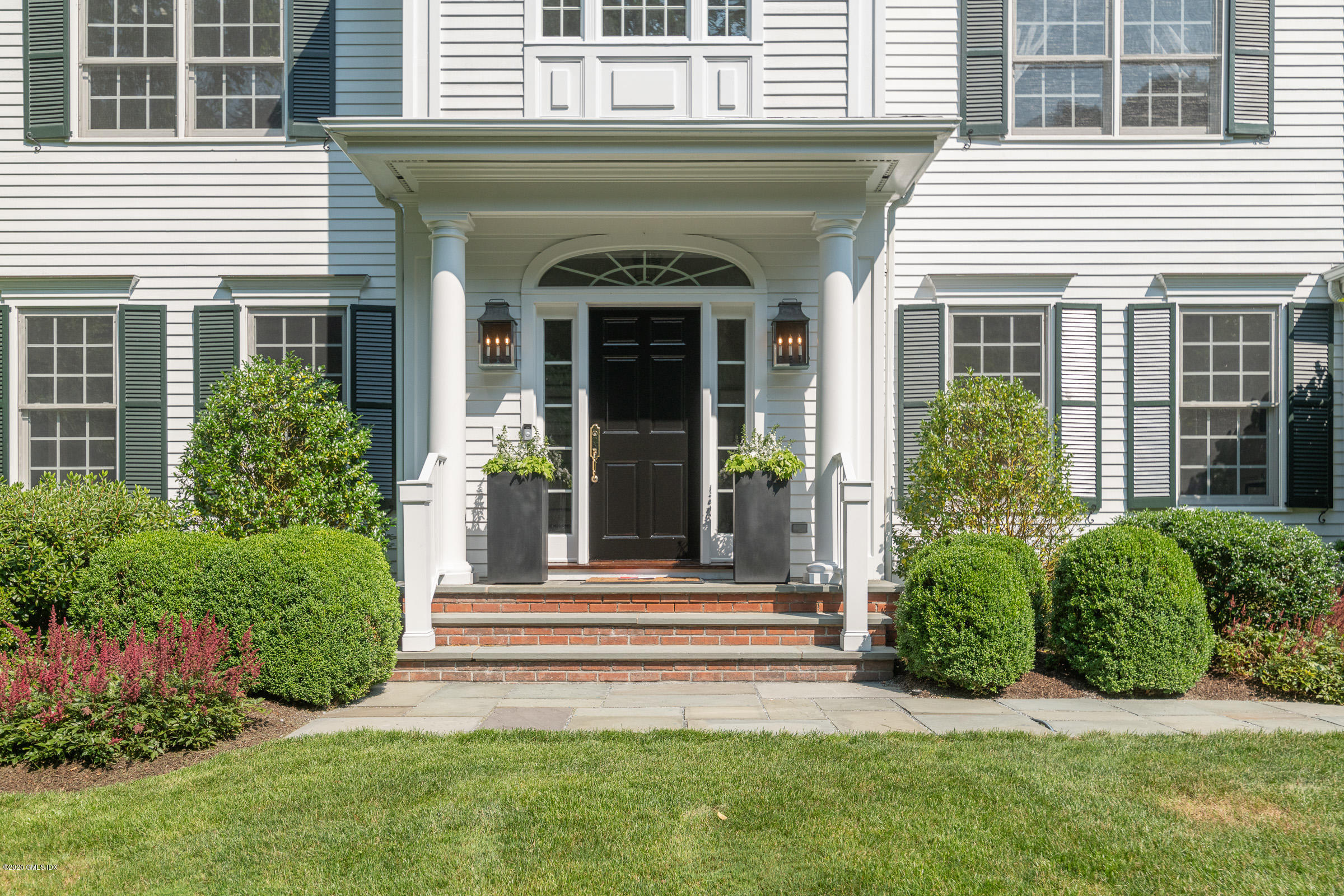 123 Valley Drive Greenwich, CT 06831 - Photo 2 of 48 a view of a house with potted plants and a table and chairs