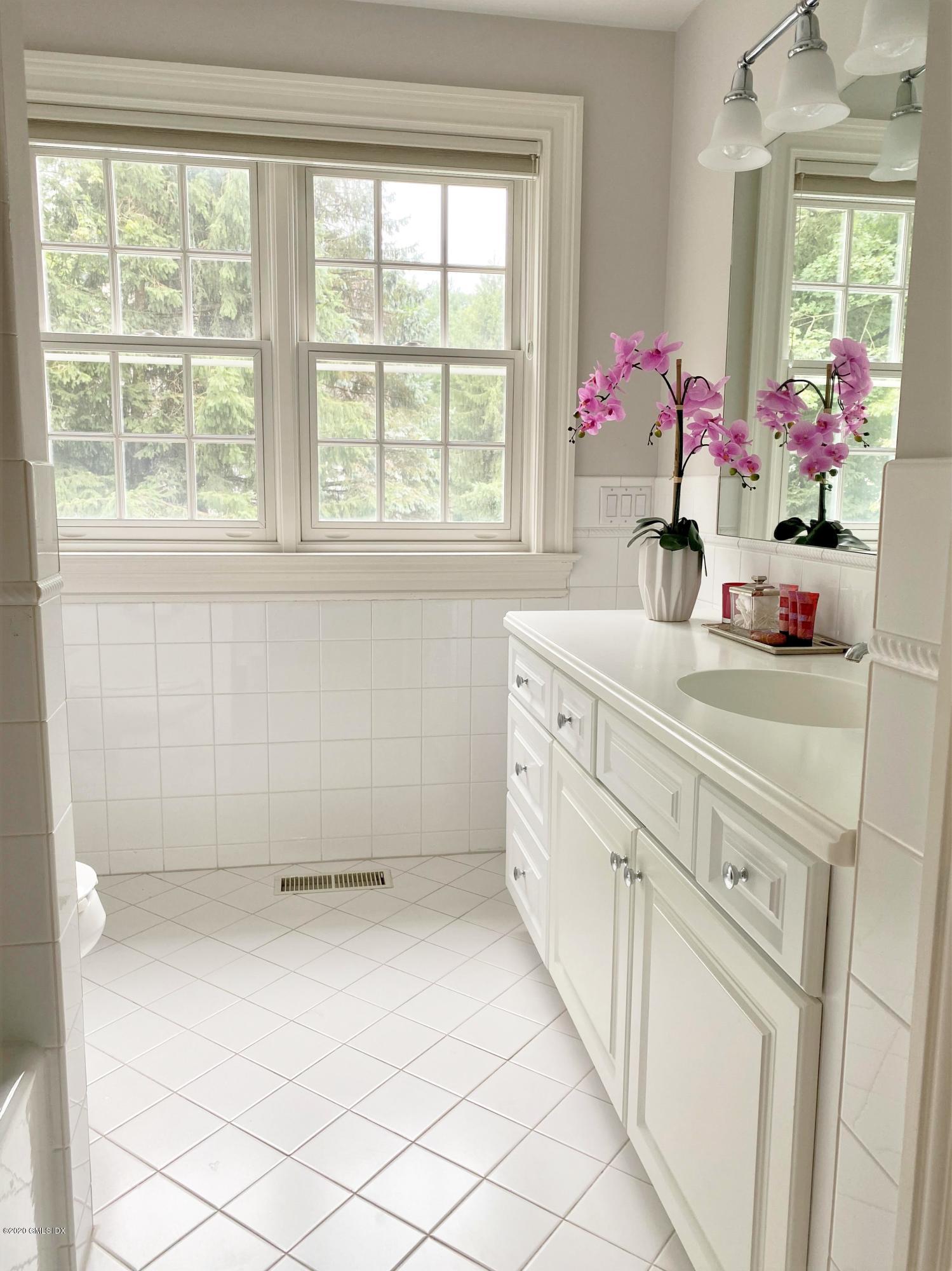 123 Valley Drive Greenwich, CT 06831 - Photo 27 of 48 a bathroom with a sink vanity mirror and next to a window