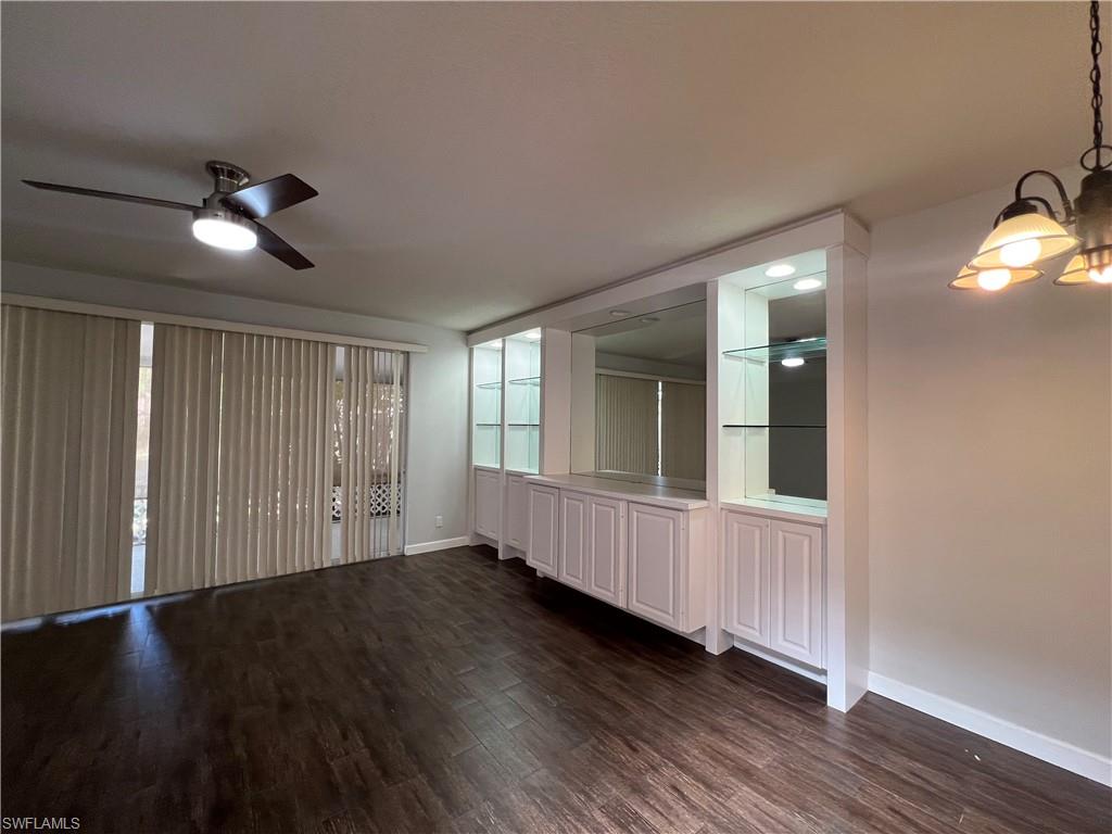 5365 Cove Circle, Unit 125 Naples, FL 34119 - Photo 13 of 36 a view of an empty room with wooden floor and a window