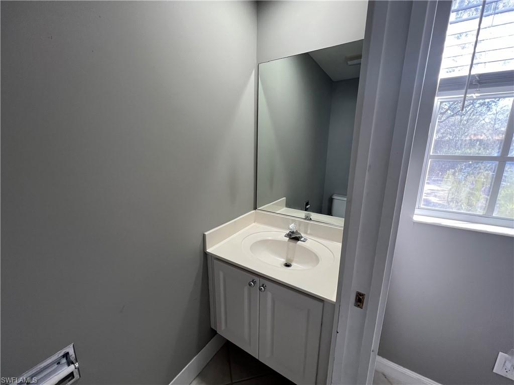 5365 Cove Circle, Unit 125 Naples, FL 34119 - Photo 16 of 36 a bathroom with a sink and mirror