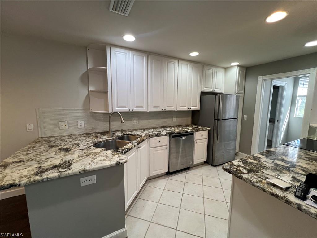 5365 Cove Circle, Unit 125 Naples, FL 34119 - Photo 19 of 36 a kitchen with a stove a refrigerator and a sink