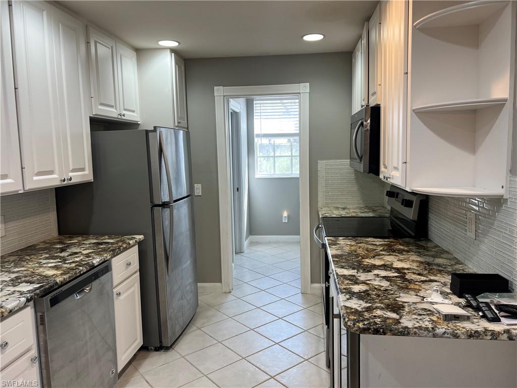 5365 Cove Circle, Unit 125 Naples, FL 34119 - Photo 20 of 36 a kitchen with kitchen island granite countertop a stove and a refrigerator
