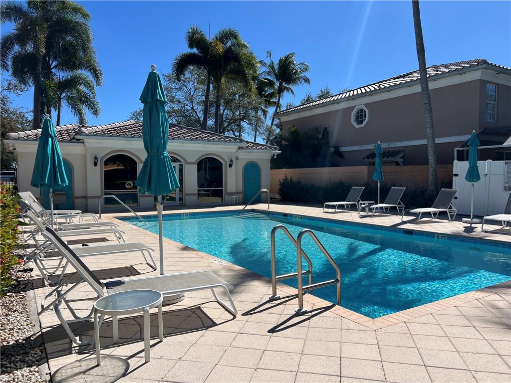 5365 Cove Circle, Unit 125 Naples, FL 34119 - Photo 2 of 36 a view of a patio with swimming pool table and chairs