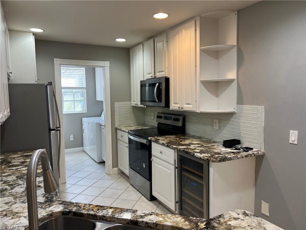 5365 Cove Circle, Unit 125 Naples, FL 34119 - Photo 22 of 36 a kitchen with stainless steel appliances granite countertop a stove a sink and a refrigerator