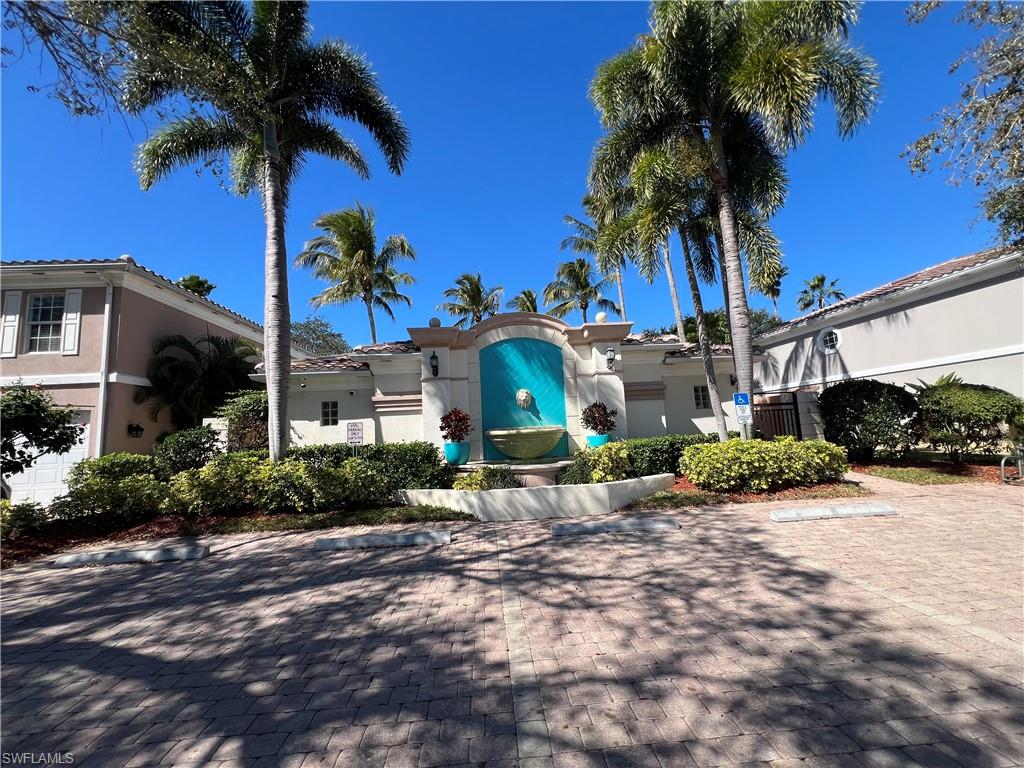 5365 Cove Circle, Unit 125 Naples, FL 34119 - Photo 3 of 36 a front view of a house with a yard and potted plants