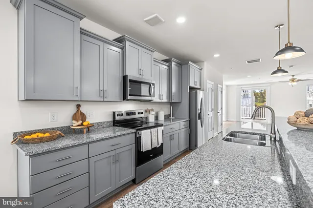 a kitchen with granite countertop stainless steel appliances and wooden cabinets