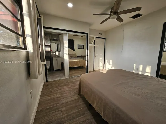 a bedroom with a bed and a large mirror