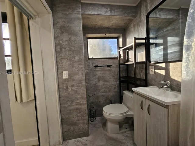 a bathroom with a toilet a sink and a mirror