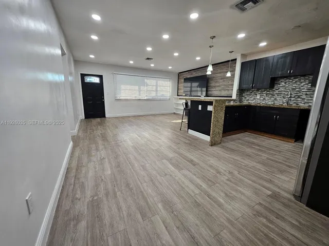 a large kitchen with stainless steel appliances kitchen island a large counter top and a sink