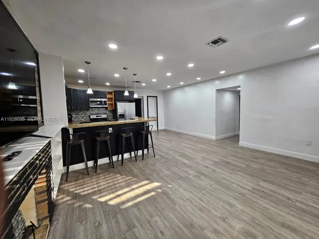 a view of kitchen with stainless steel appliances kitchen island