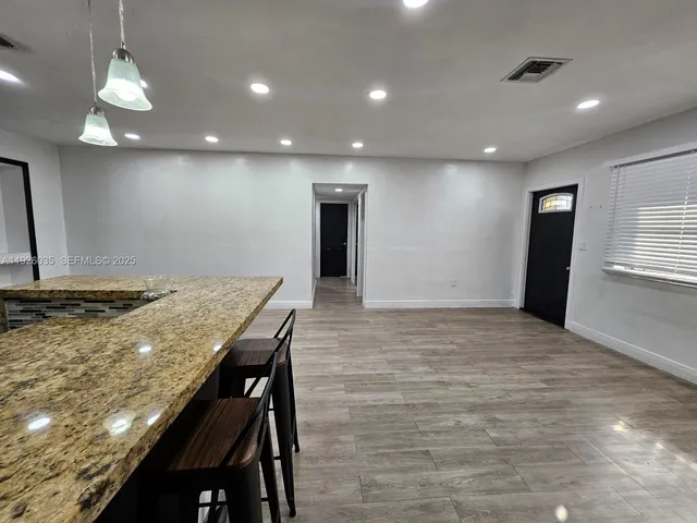 a kitchen with kitchen island a sink stove and refrigerator