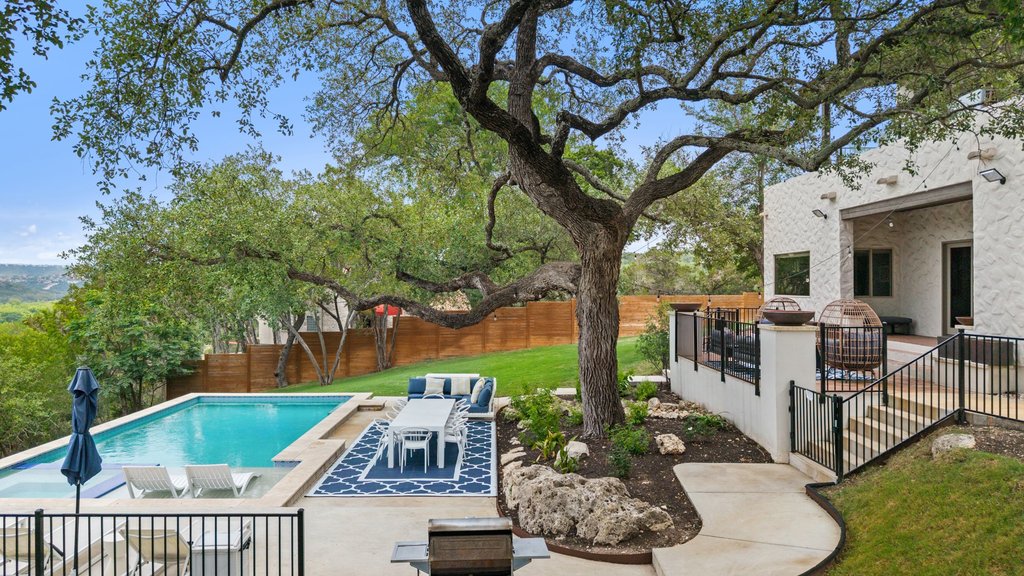 716 North Commons Ford Road Austin, TX 78733 - Photo 21 of 30 Expansive outdoor living area featuring a rectangular swimming pool with integrated spa, concrete patio, and mature tree