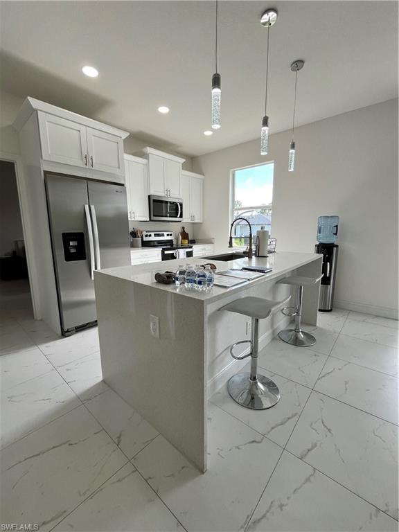 3313 68th Street West Lehigh Acres, FL 33971 - Photo 11 of 26 Kitchen with white cabinets, recessed lighting, refrigerator, stove, and marble finish floor