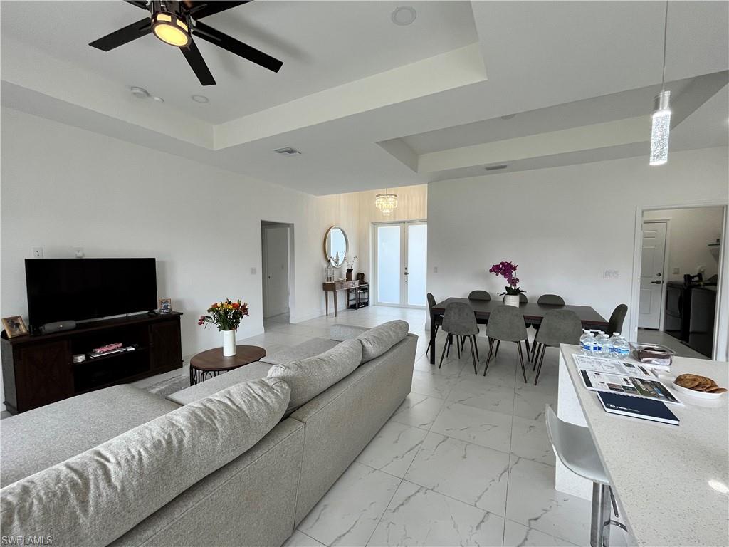 3313 68th Street West Lehigh Acres, FL 33971 - Photo 12 of 26 Living area with a raised ceiling, ceiling fan, and light marble finish floors