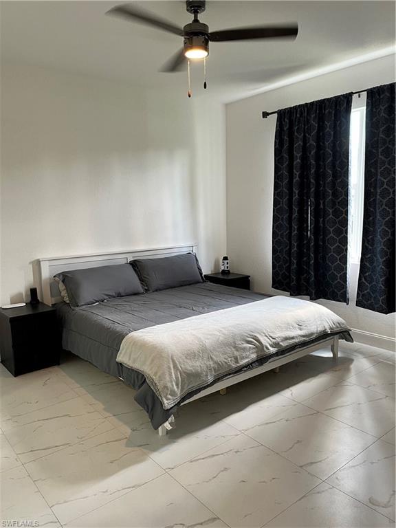 3313 68th Street West Lehigh Acres, FL 33971 - Photo 14 of 26 Bedroom featuring marble look tiles and ceiling fan