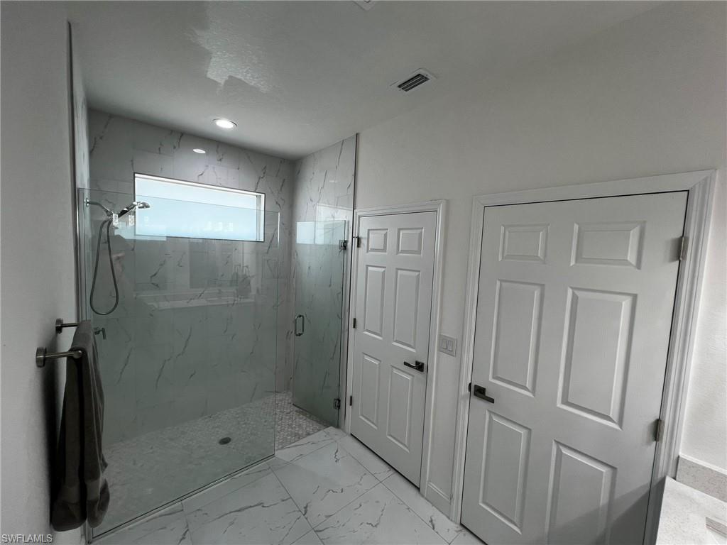 3313 68th Street West Lehigh Acres, FL 33971 - Photo 19 of 26 Bathroom with marble finish floor, a marble finish shower, and visible vents