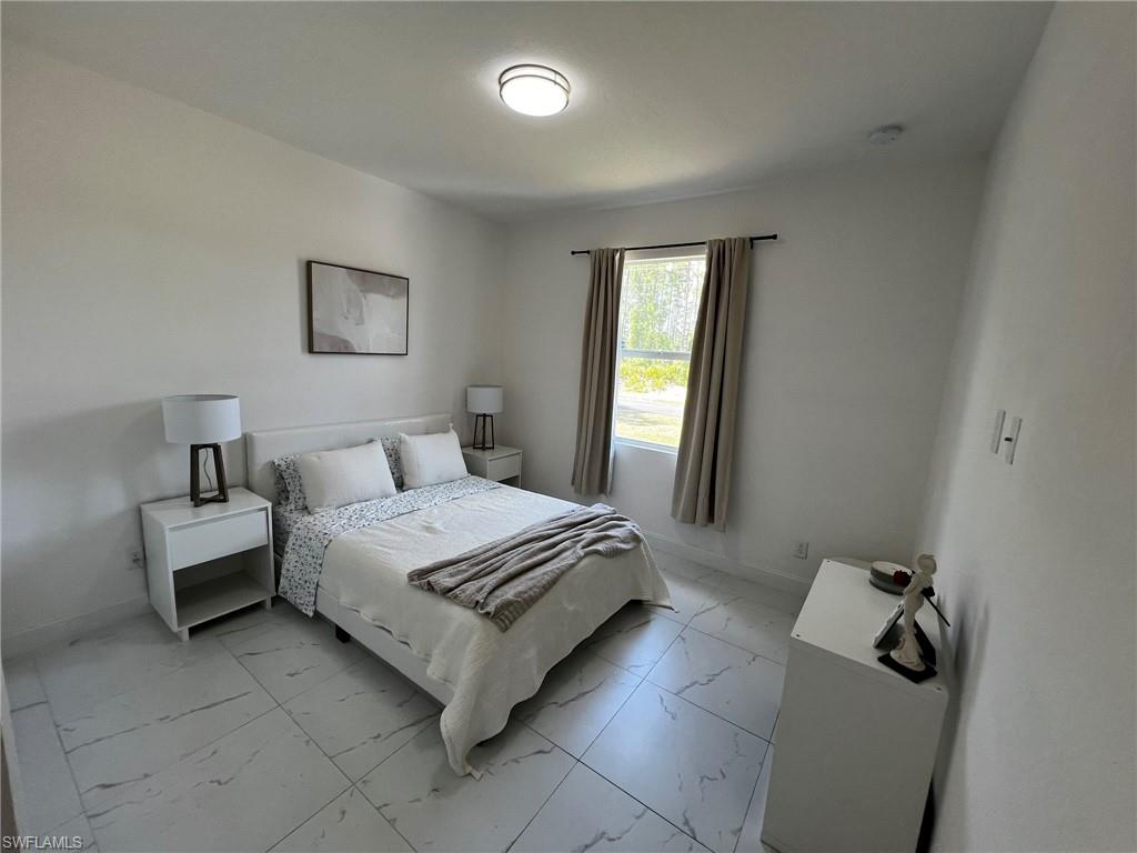 3313 68th Street West Lehigh Acres, FL 33971 - Photo 22 of 26 Bedroom with marble finish floor and baseboards