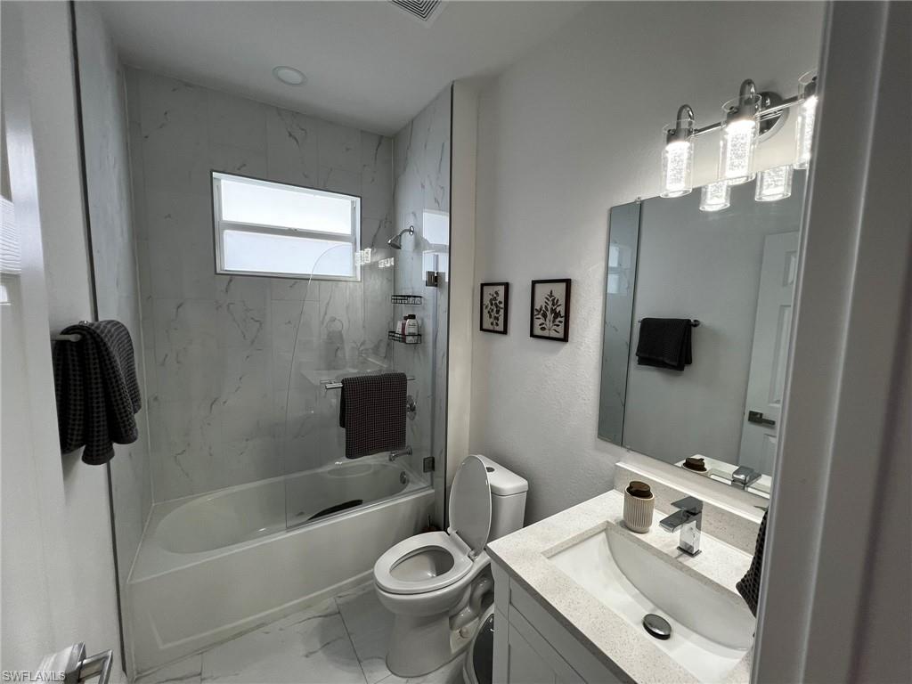 3313 68th Street West Lehigh Acres, FL 33971 - Photo 25 of 26 Bathroom with marble finish floor, toilet, vanity, and shower / bath combination
