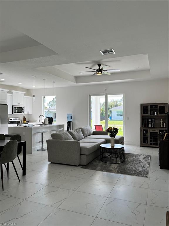 3313 68th Street West Lehigh Acres, FL 33971 - Photo 8 of 26 Living room with a tray ceiling, a ceiling fan, visible vents, recessed lighting, and marble finish floor