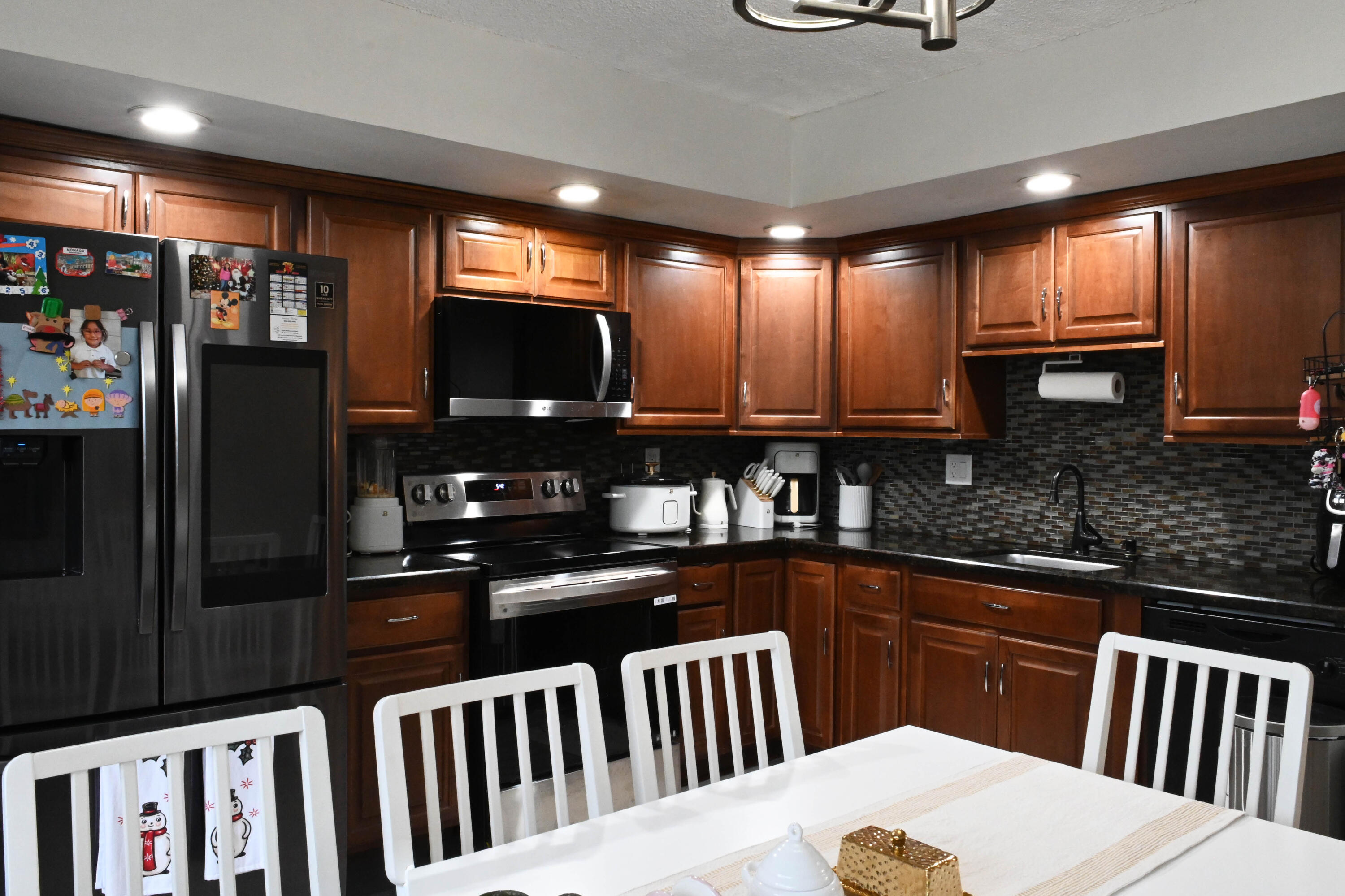 8400 Southwest 133rd Avenue Road, Unit 311 Miami, FL 33183 - Photo 3 of 11 a kitchen with granite countertop a refrigerator a sink a stove top oven and cabinets