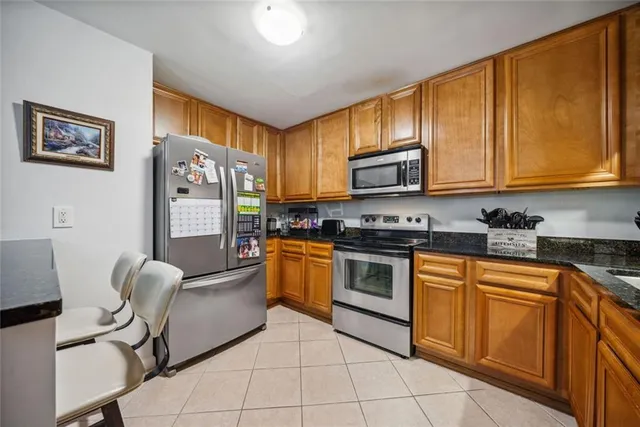 a kitchen with stainless steel appliances granite countertop a stove top oven a sink dishwasher and cabinets with wooden floor