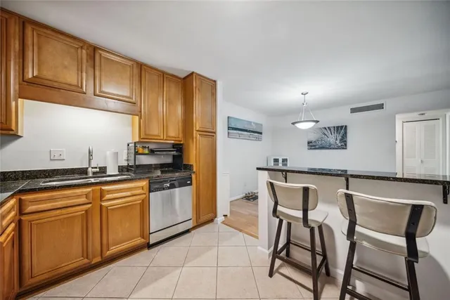 a kitchen with stainless steel appliances granite countertop a stove a sink dishwasher and a refrigerator