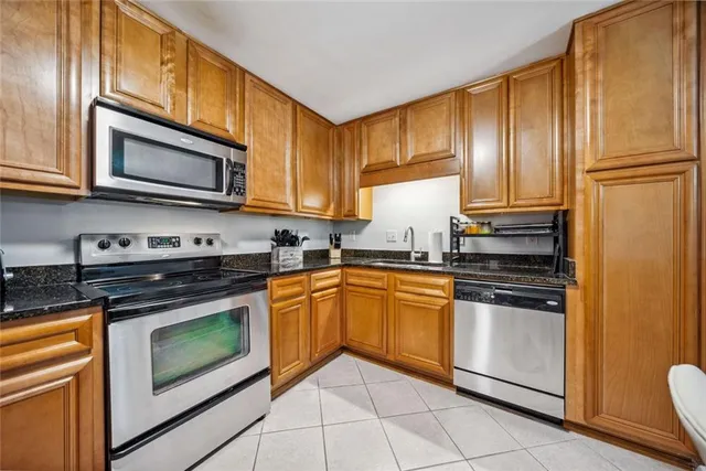 a kitchen with stainless steel appliances granite countertop a stove microwave and cabinets